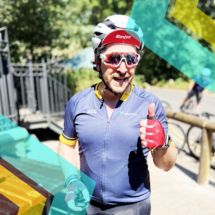 A man is giving a thumbs up while riding for Surrey Cycling Club.