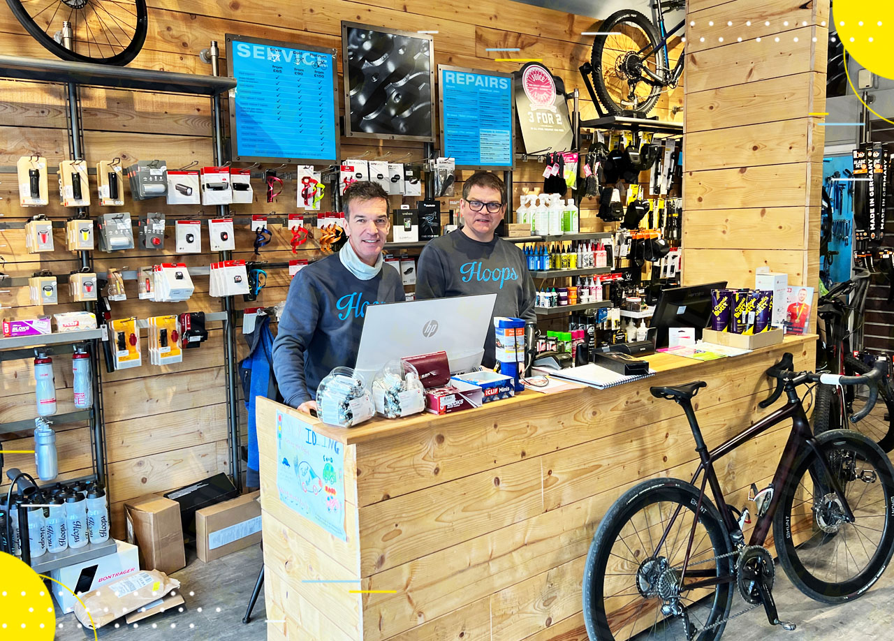 Two men standing in front of a bicycle shop.