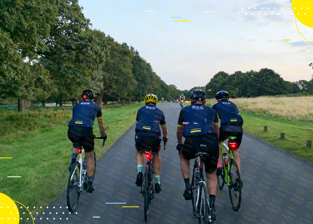 A group of cyclists riding bikes down a road.